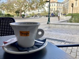 Coffee cup on the edge of the table with Mitropoli Square in the background. Athens, Greece