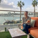Woman sitting on an orange couch overlooking a marina