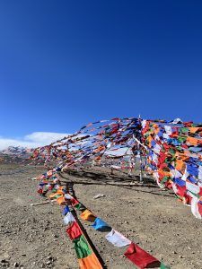 Colourful prayer flags set against a deep-blue sky